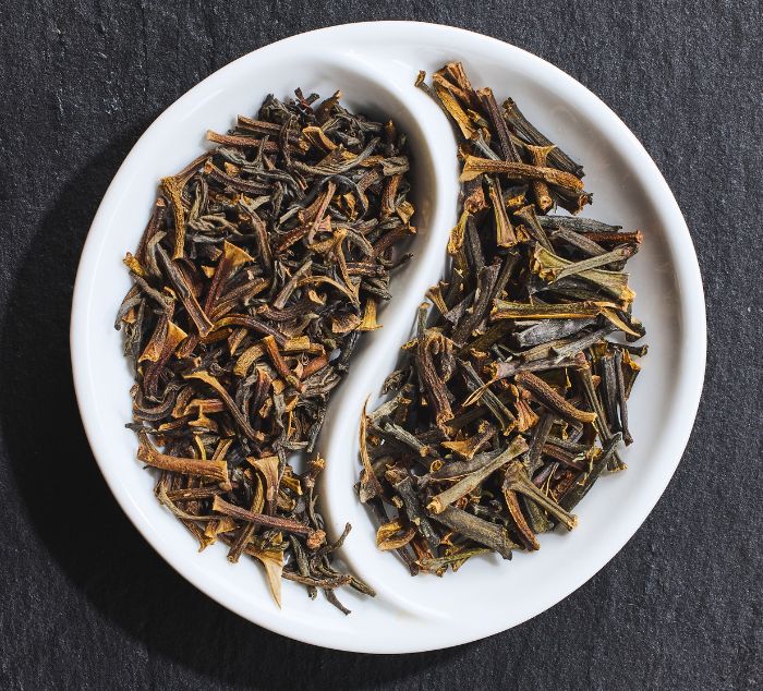 Ceylon Cinnamon Twig Tea arranged in a yin-yang symbol on a white ceramic dish against a dark slate background.